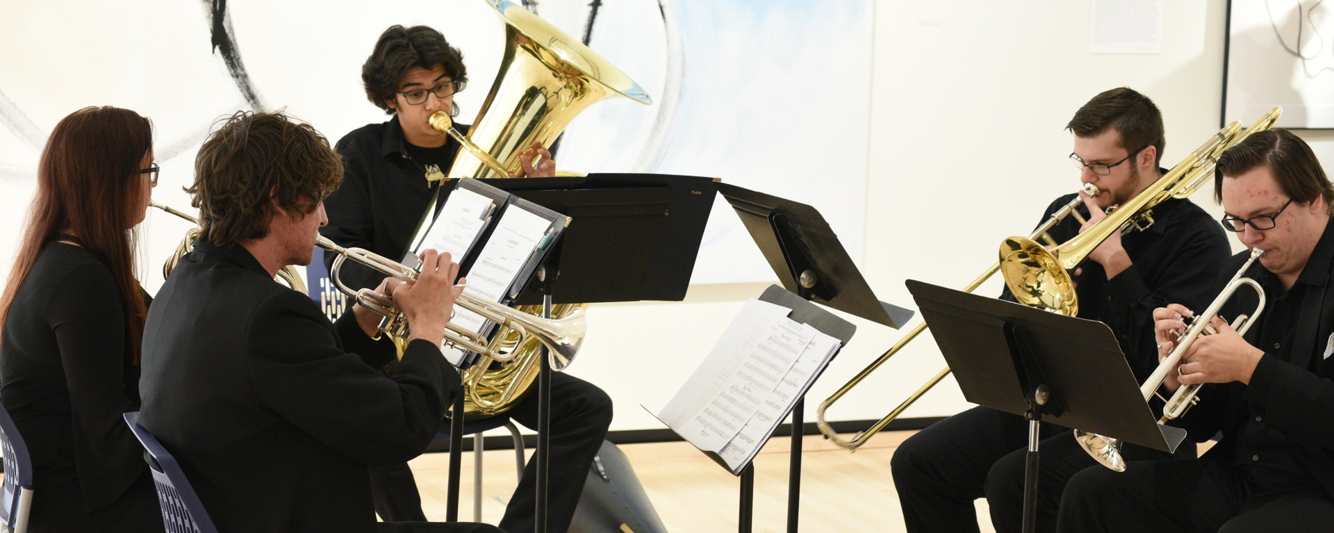 Students playing brass instruments in performance